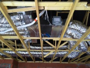 Vue du dessous d'un assemblement de tuyaux en alu posés sous un toit.